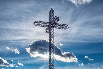 Iron cross of a mountain peak with sky in background