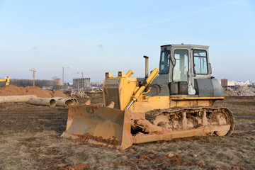 Bulldozer at construction site. Heavy equipment for digging, demolition, construction and ground works. Dozer for earth-moving, land clearing, grading, utility trenching and foundation digging
