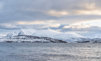 Fototapeta na wymiar winter landscape at polar dawn on Kvaløya Island and fjord near Tromso, northern Norway