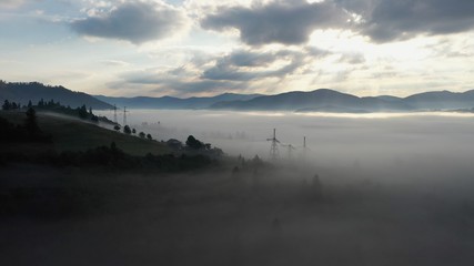Aerial view of colorful mixed forest shrouded in morning fog on a beautiful autumn day