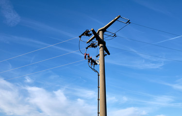 Close-up of a high voltage pylon made of concrete seen from below against blue sky with copy space...