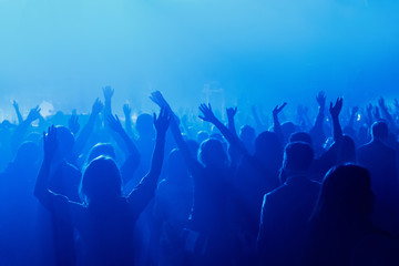 Silhouette of crowd raised hands on concert, music show.