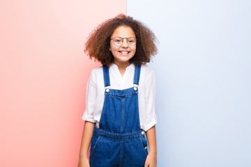 african american little girl looking happy and goofy with a broad, fun, loony smile and eyes wide...