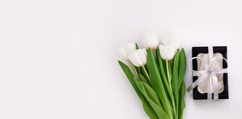 Spring website header template. White tulip black gift box with silver ribbon on light background flat lay. Text place 8 March Happy Mothers Day Sales.Bouquet greeting card. Copy space banner top view