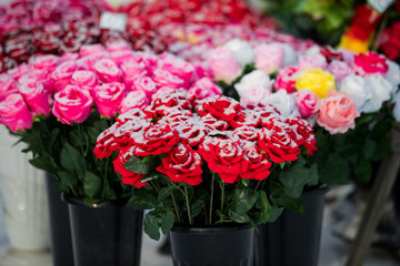 a point of sale with many artificial flowers, bouquets and wreaths near the cemetery sells jewelry and traditional offerings to the graves of the dead in memory of living relatives