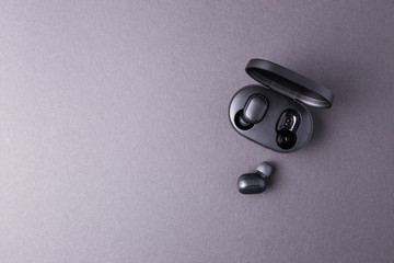 Black wireless headphones close-up on a black isolated background.