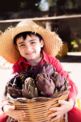 kid smiling with basket of artichoke