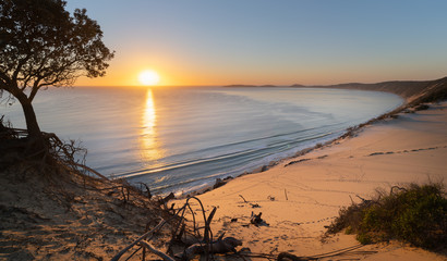 Sunrise at carlo sand blow queensland with calm seas and golden sand clolour
