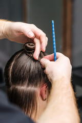 Hairdresser working with wet woman's hair during making hairstyle, close up.