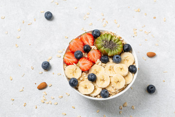 Delicious healthy Breakfast. Smoothie bowl with granola, strawberries, blueberries, bananas, kiwi and nuts. Selective focus 