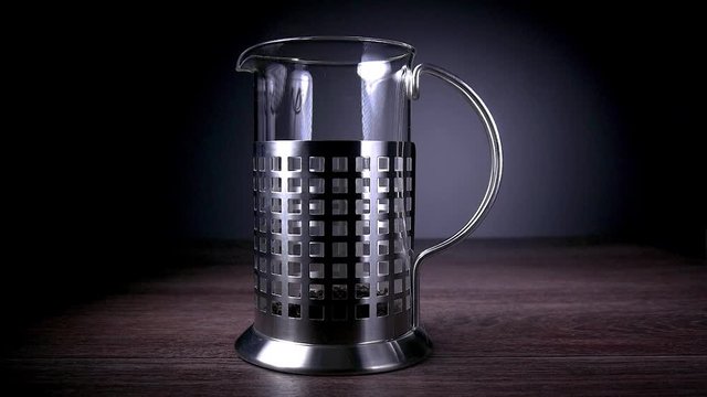 Glass teapot for tea on a dark background