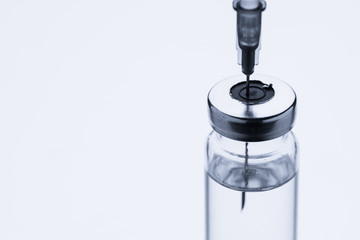 Ampoules for injection. Glass medical vials for vaccination. Transparent bottles and disposable syringe on a white background. Antibiotic for treating the virus.