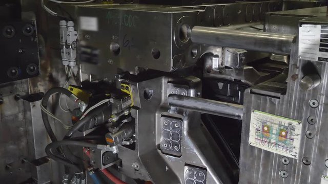 Automatic Plastic Injection Molding Machine, Robotics Arm Removes the Finished Headlamps Housing from the Injection Mold and Put it on the Conveyor Belt in Automotive Factory