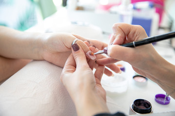 Manicure process in beauty salon - woman hand nails care.