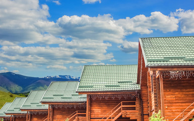 wooden cabin cottages rustic architecture building foreground and vivid highland landscape background space with blue sky and white clouds travel and tourism concept advertising picture