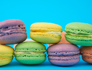 multi-colored round baked macarons cakes on a light blue background