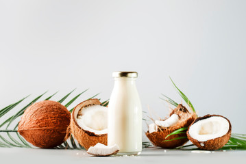 Coconut non dairy vegan milk in bottle with shell. Gray backgound with copy space