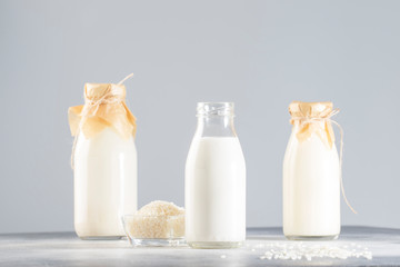 Vegan rice plant based milk in bottles, closeup, gray background. Non dairy alternative milk....