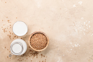 Vegan Buckwheat plant based milk in bottles, closeup, brown background. Non dairy alternative milk. Healthy vegetarian food and drink concept. Copy space, top view