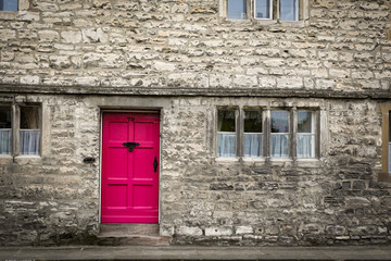 Fototapeta na wymiar Stone building with bright pink door