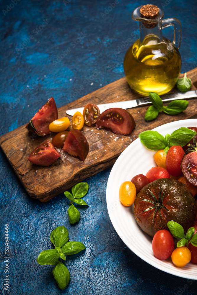 Wall mural vibrant fresh tomatoes. vegan food market fresh. colorful tomatoes on conrete background