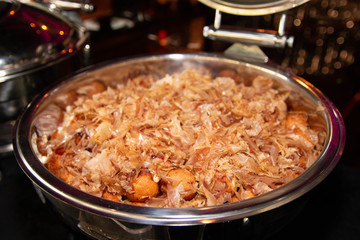 Large portion of Japanese style Takoyaki with dried bonito flakes on top in a buffet tray.