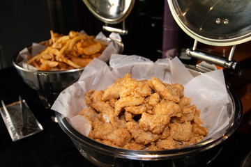Fried chicken and french fries on a buffet tray.