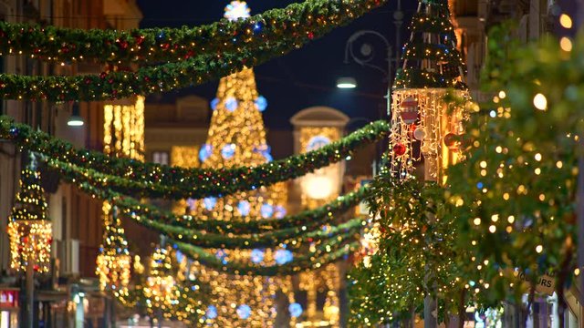 Christmas tree with decoration light and Christmas street illumination in the city during Christmas and New Year Holidays. Blured background. Sorrento, Italy. UHD, 4K
