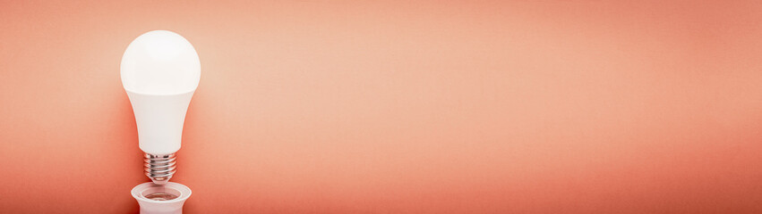 LED lamp inverted from a cartridge on a red background with copy space web banner: concept of...