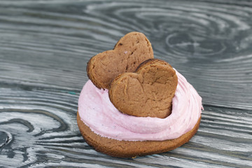 Marshmallows sandwiches made from chocolate dough and blueberry marshmallows. Decorated with cookies in the shape of hearts. On brushed pine boards. Close-up shot.