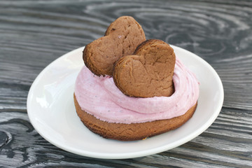 Marshmallows sandwiches made from chocolate dough and blueberry marshmallows. Decorated with cookies in the shape of hearts. On brushed pine boards. Close-up shot.