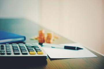 finance business background with calculator pen money and paperwork on desk for accounting and analyzing investment at office work space. banking , savings , accountant , finances and economy concept.