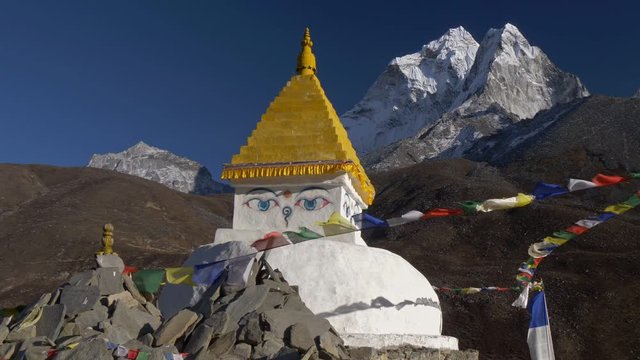 Buddhist stupa with prayer flags on track to the base camp of Everest (EBC) in the Himalayas, Nepal. Steadicam shot