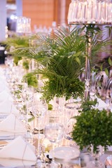 Palm tree leaf wedding table. Candles, napkins and mirrored tables.