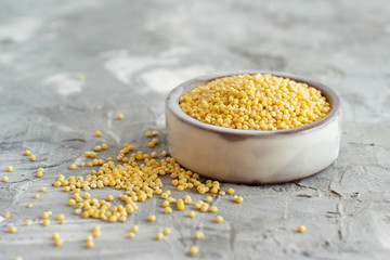 Raw dry hulled millet in a ceramic bowl