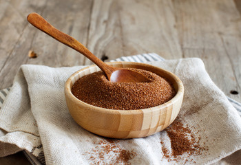 Raw teff grain in a wooden bowl close up