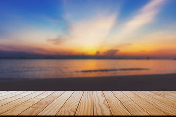 Fototapeta na wymiar Sunset on the beach with empty wood table top.