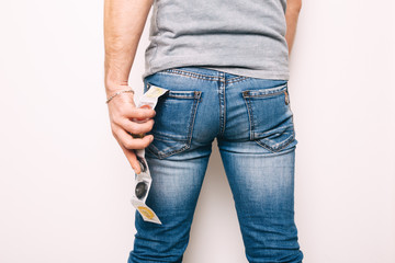 a young man's athletic ass in jeans. condoms in the jeans' pocket. concept: first date, protection...