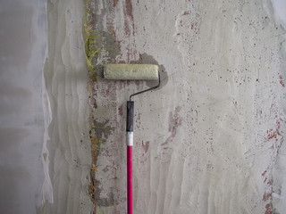 roller for repair on the background of a concrete wall, repair and design. Wall before repair