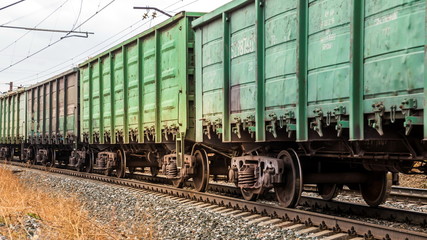 a freight train with bulk wagons rushing along the railway.