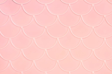 Lihgt pink ceramic tiles in the form of scales. Mosaic Tiles on the wall