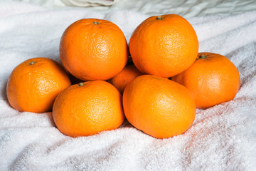 Fresh oranges on the white towel background.