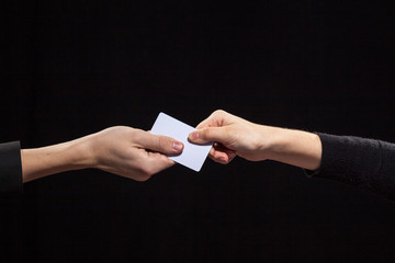 The business card is held by two, male and female hand