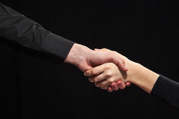 Handshake on a black background.