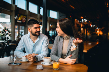 romantic couple in cafeteria drinking coffee and talking