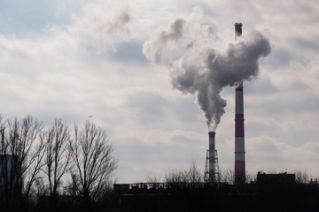 Industrial Landscape, Krakow, Poland: White-red high pipes of the plant with smoke or steam coming...