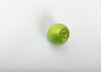 A single green fresh apple isolated on white background. top view