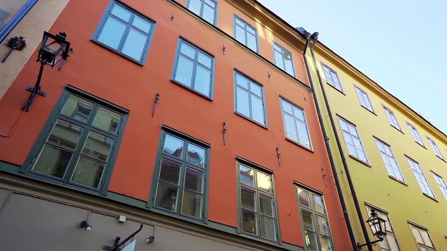 Apartment buildings on european streets in old northern city. Scandinavian windows. Facades of colorful houses in narrow streets of Stockholm, Sweden. Traveling concept. Slow motion. Steadicam shot