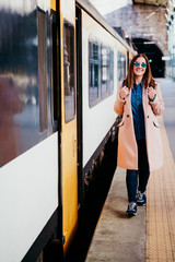 happy young woman walking at train station. Travel concept