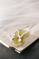 Tray and diamond necklace with yellow gemstone.